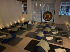 Image of Serenity Barn setup for Sound Healing with Geet Fateh. Image shows yoga mats and blankets in rows with the gong at the end